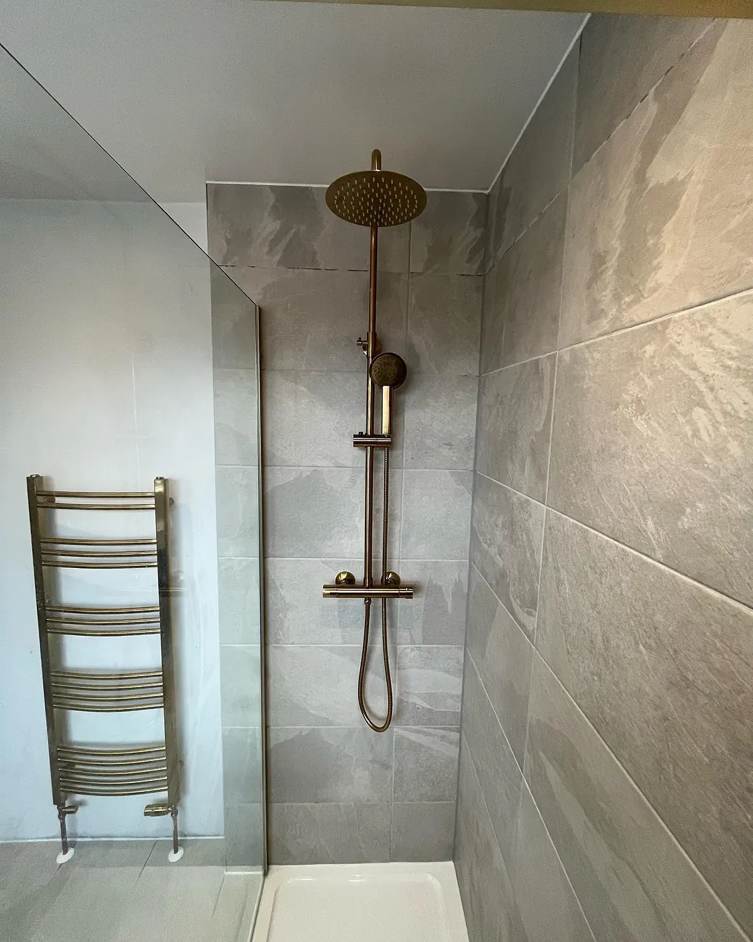 Brushed brass rain shower, handset and heated towel rail